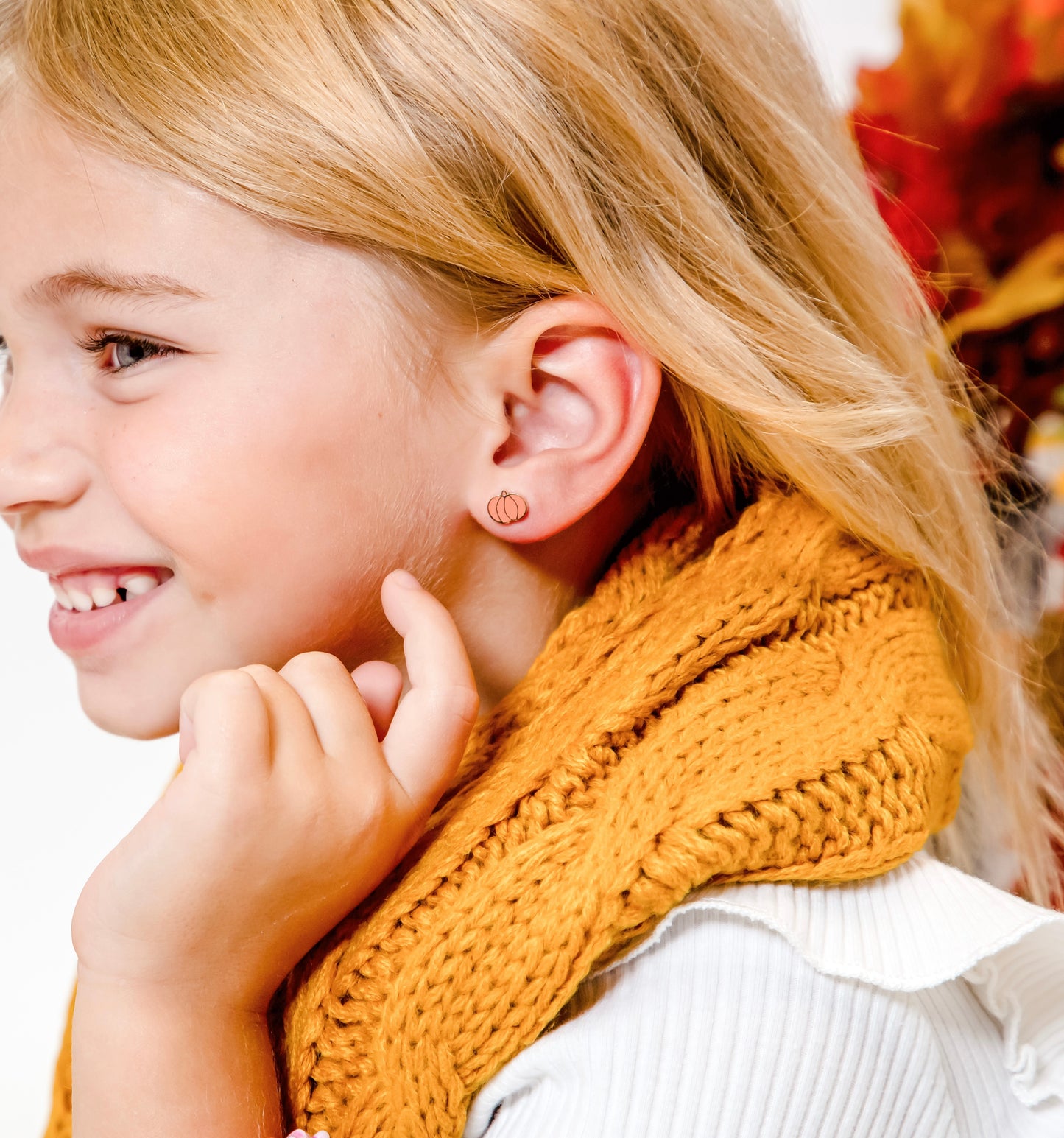 girl pointing at gold flatback pumpkin stud